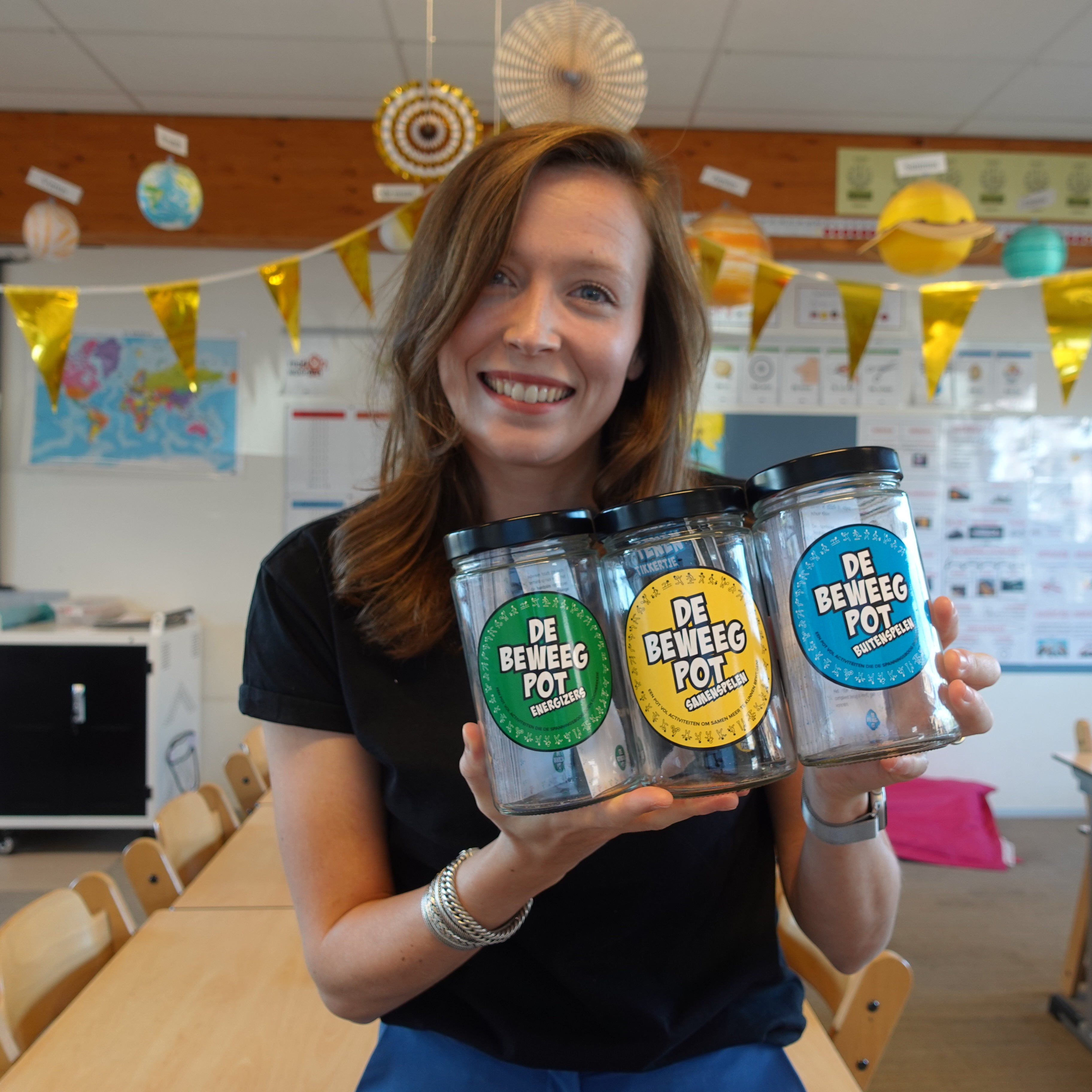 foto van juf jasmijn met de drie beweegpotten energizers, samenspelen en buitenspelen